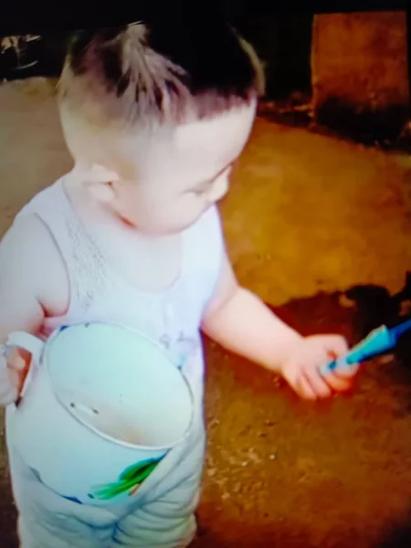 little girl with a toy paints in the kitchen