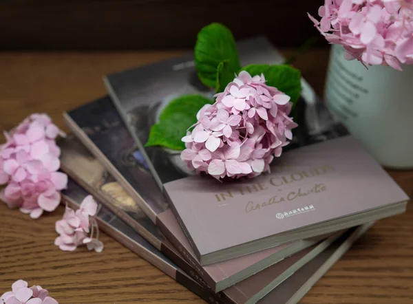 pink peony flowers and a book on a wooden background