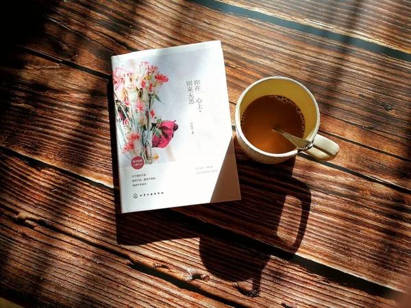 cup of coffee and a book on a wooden background