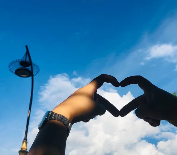 heart in hand on sky background