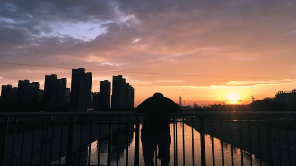 silhouette of a man on the bridge at sunset