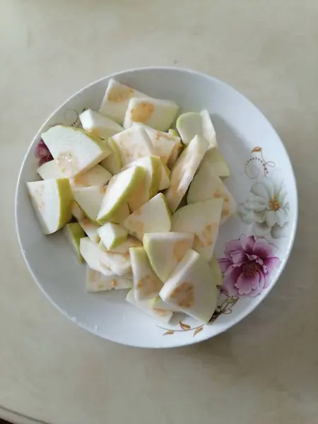 stock image fresh sliced white and yellow pear with a slice of lemon on a plate