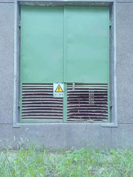 green metal door with a white wall