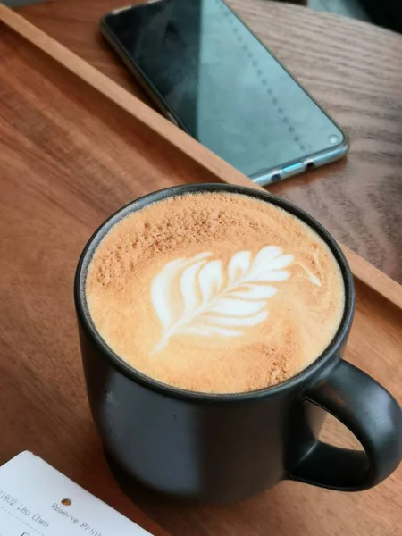 cup of coffee and a notebook on a wooden table