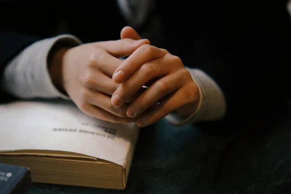 close up of a man praying with a bible
