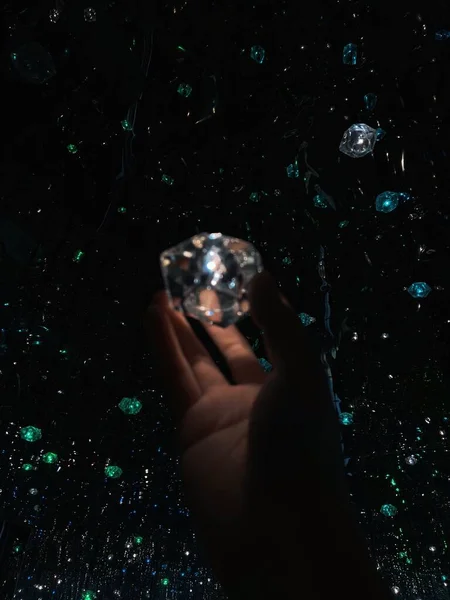 hand holding a crystal ball on a black background