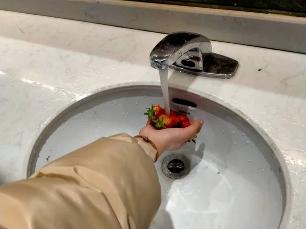 woman washing water with fresh fruits