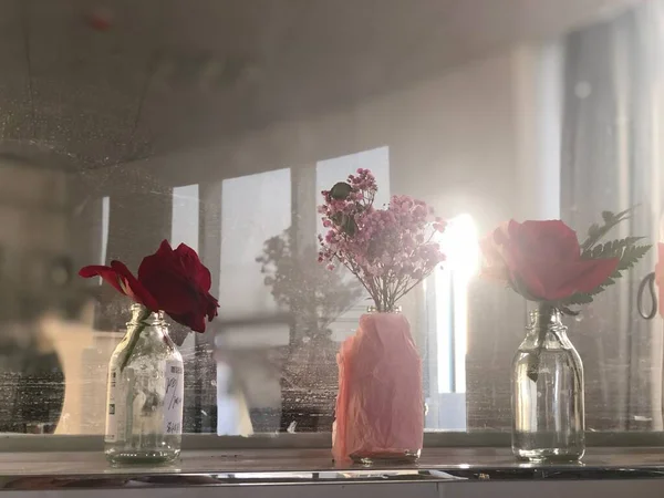 beautiful bouquet of roses in a glass vase on the windowsill