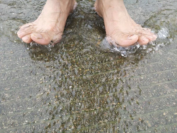 man\'s feet in the water