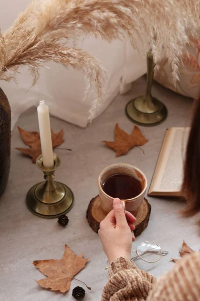 autumn composition with a cup of coffee and a book on a wooden background