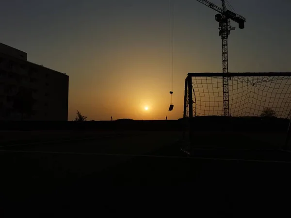 silhouette of a basketball stadium at sunset