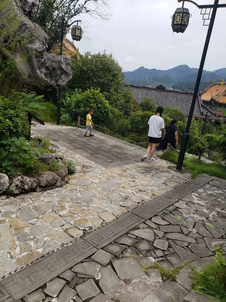 a man in a green dress with a backpack on the road