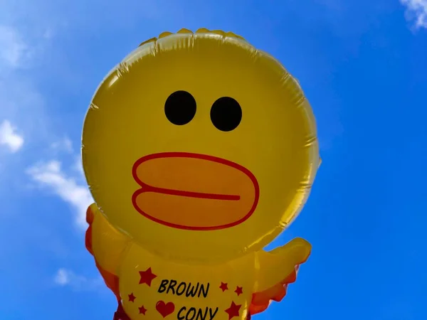 yellow balloon with a smile on the background of the sky