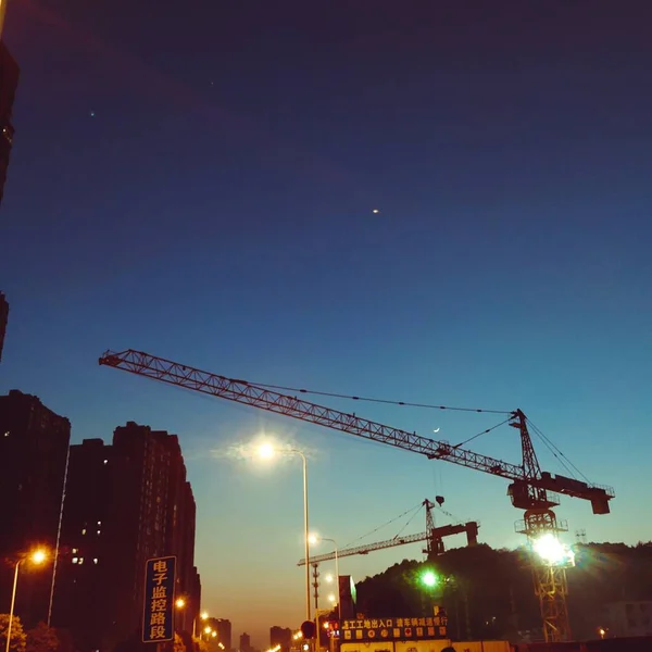 silhouette of a construction crane on a background of a building