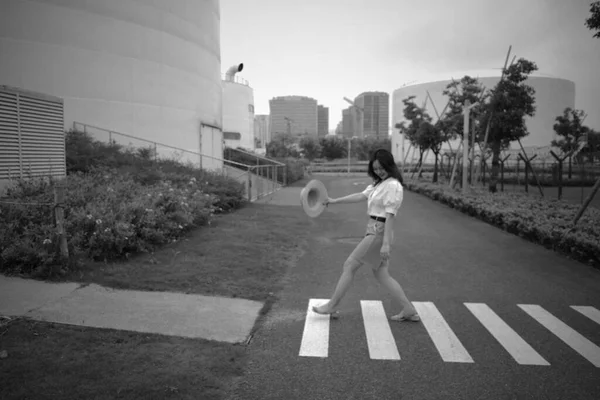 young girl in black clothes and a white t-shirt and shorts on the street