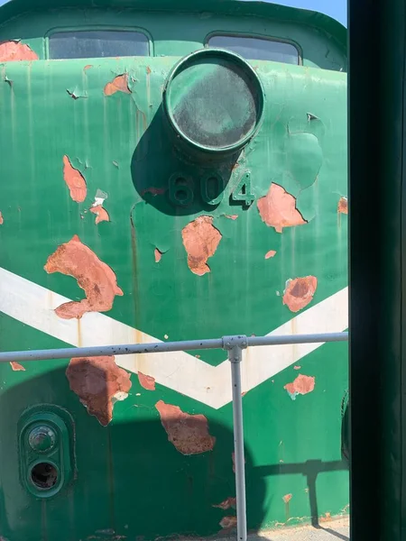 old rusty metal container with a green handle