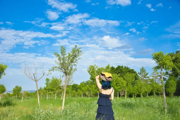 young woman in a white dress and hat on a background of green grass