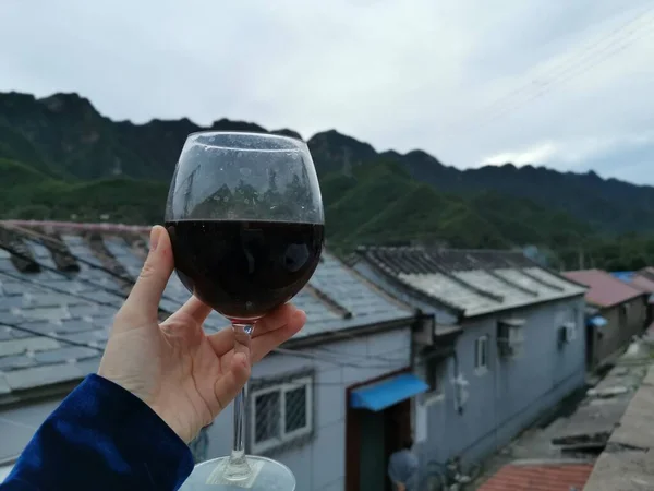 a glass of red wine on the background of the mountains