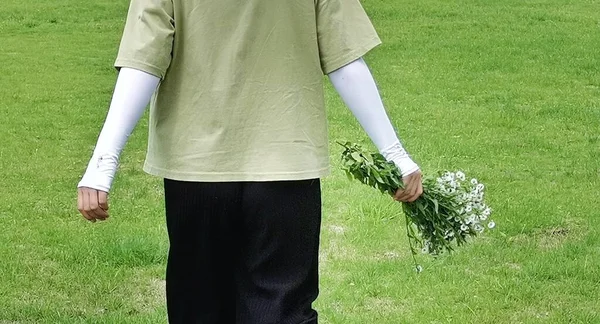 a man in a white shirt and a green dress with a bouquet of flowers