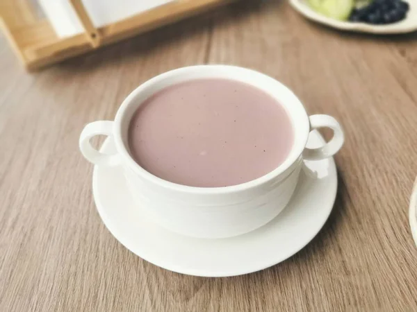 coffee cup with fresh berries on wooden table