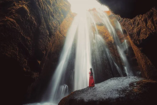 young woman with waterfall in the forest