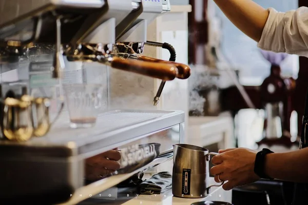 barista pouring coffee in a cafe