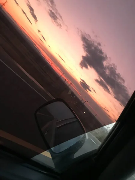 car driving through the window of the sunset.