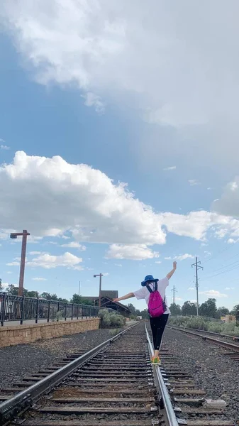 a man in a suit and a backpack on the railway tracks