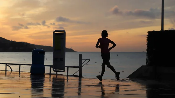 silhouette of a woman running on the beach