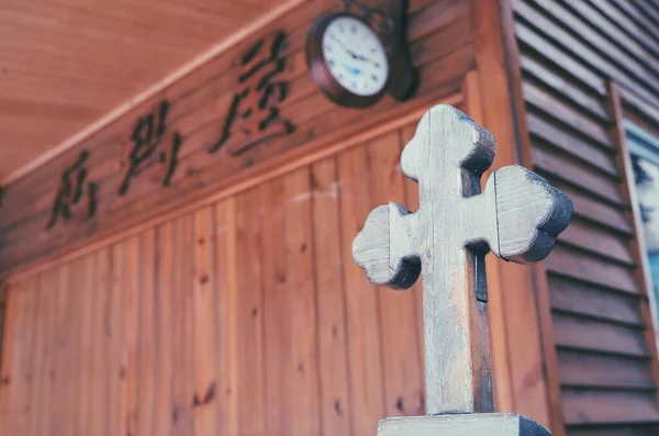 old wooden cross on the background of the church