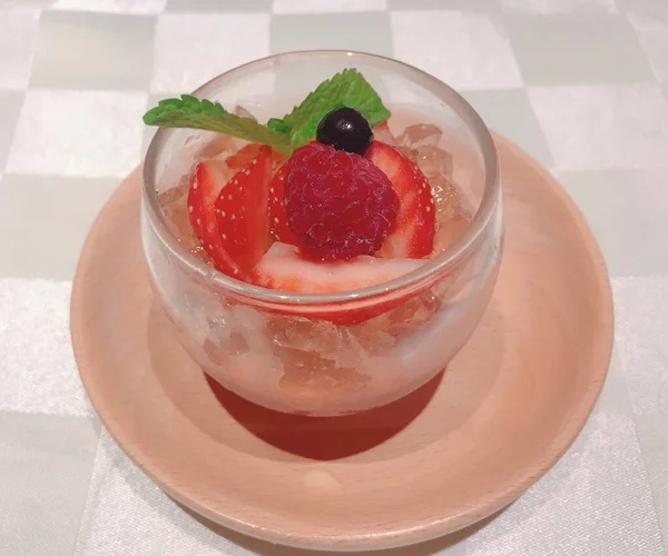 strawberry jelly with strawberries and mint in a glass jar on a white background