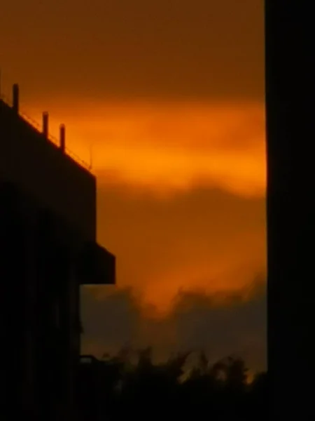 silhouette of a house with a sunset