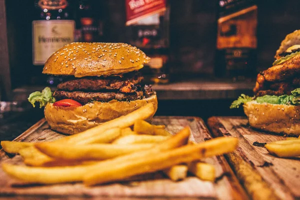 delicious burger with cheese and vegetables on wooden table