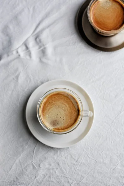 cup of coffee and white cups on a wooden background