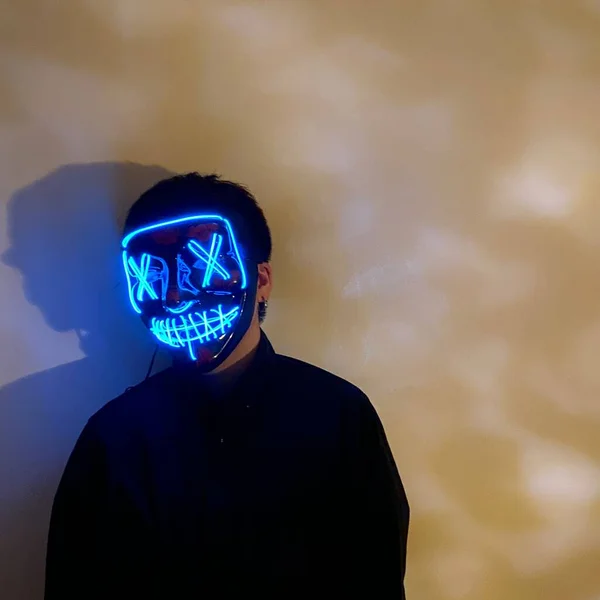 man in a black t-shirt with a mask on the background of the smoke