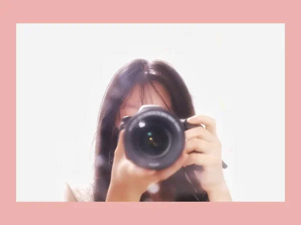 young woman with camera on the background of a white wall