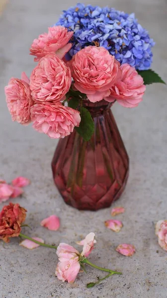 beautiful bouquet of pink roses in a vase on a wooden background