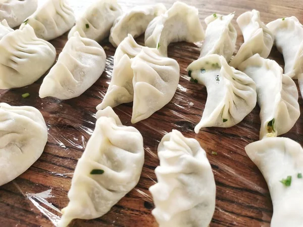 raw dumplings on a wooden board