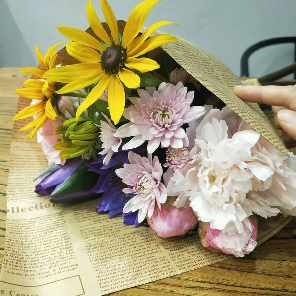 bouquet of flowers and a book on a wooden background