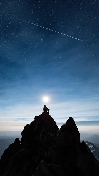 silhouette of a mountain with a star in the background