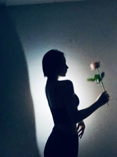 silhouette of a young woman with a bouquet of flowers