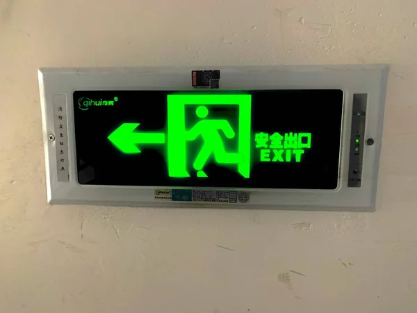green emergency exit sign on a wall