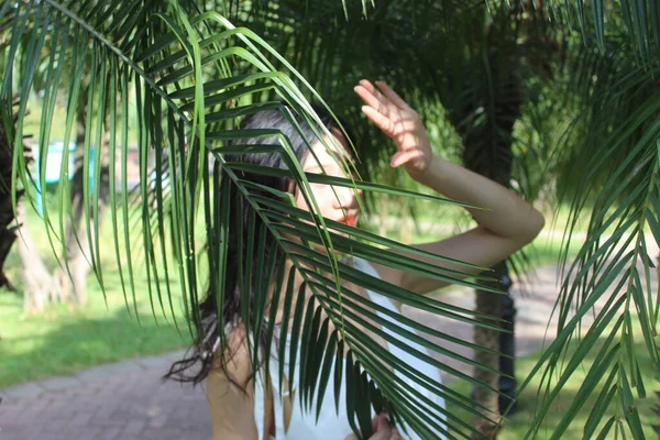 woman in a hammock with palm leaves