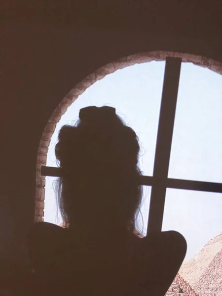 silhouette of a man in a black dress with a window