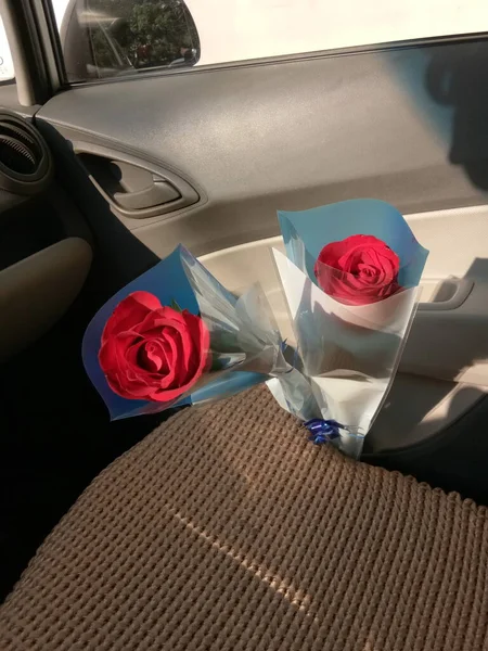 car with red roses