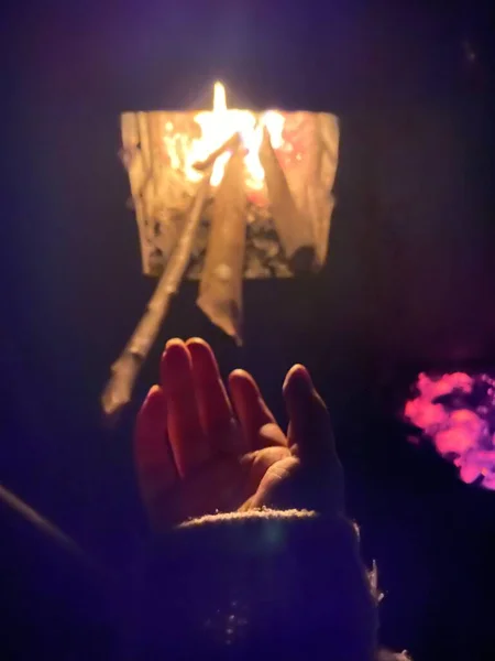 hand holding burning candle in the hands of a church
