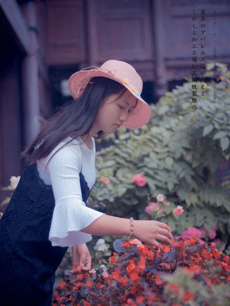 young woman with a bag of flowers in the garden