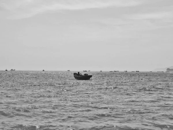 black and white photo of a boat on the sea