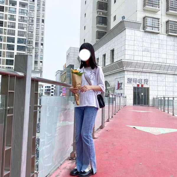 young woman in a protective mask and a scarf on the street