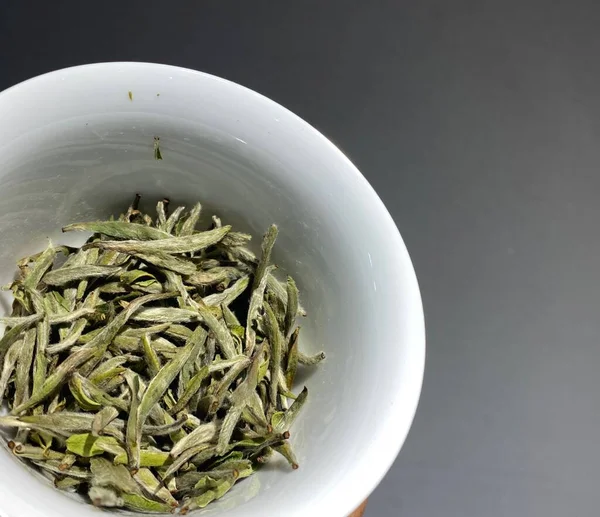 dried green tea leaves on a white background